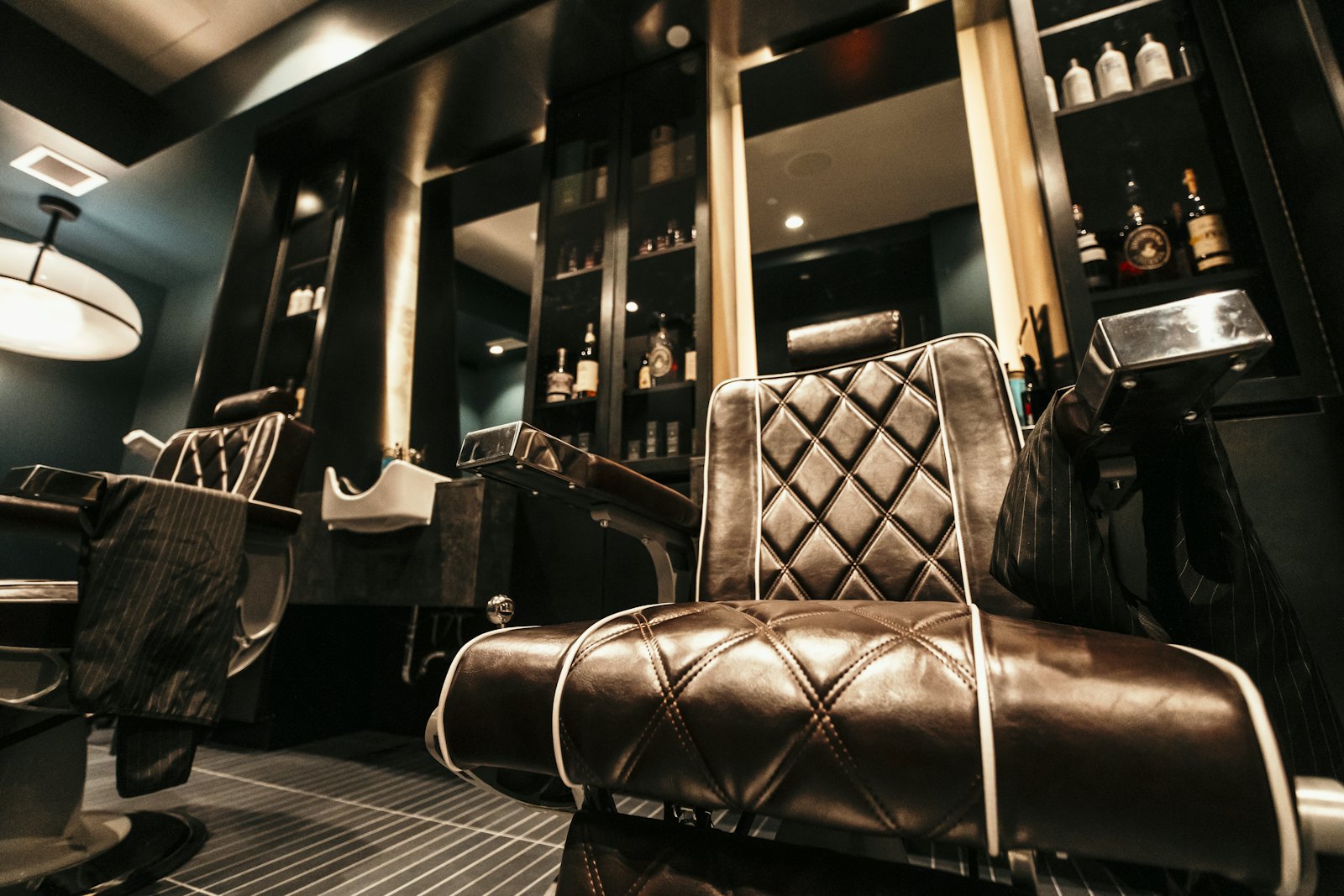 The chairs and mirrors along the back wall of Fade House, lit low