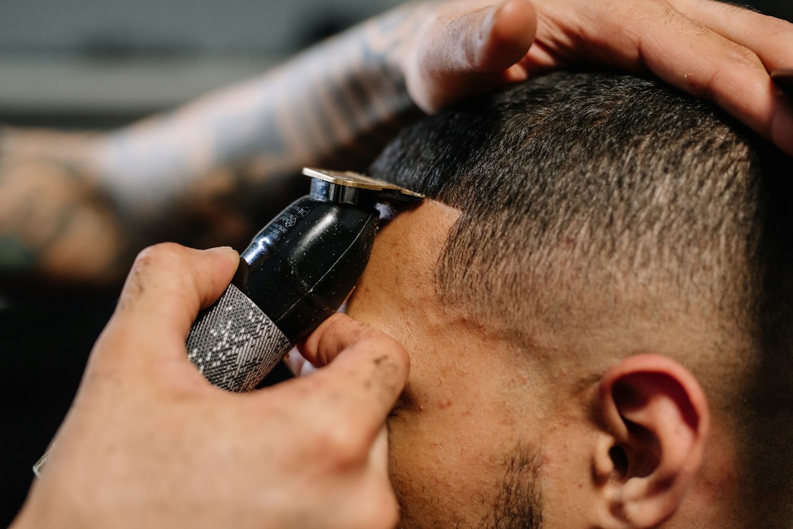A fade being blended into the temple with a trimmer, close in