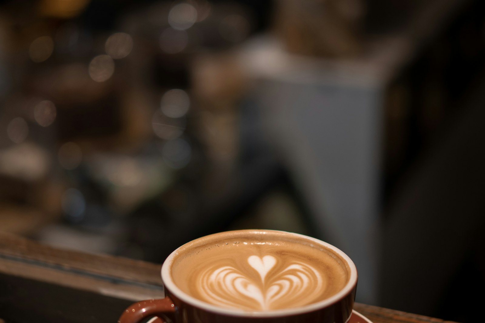 A cappuccino with a poured rosetta, sat on the counter